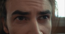 Closeup of the eyes of a sad, anxious, emotional man in church.