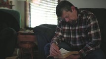 a man praying and reading a Bible 