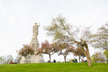 National Monument to the Forefathers framed by blossoming trees