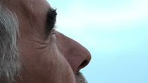 Close up of an older man look up at the sky.