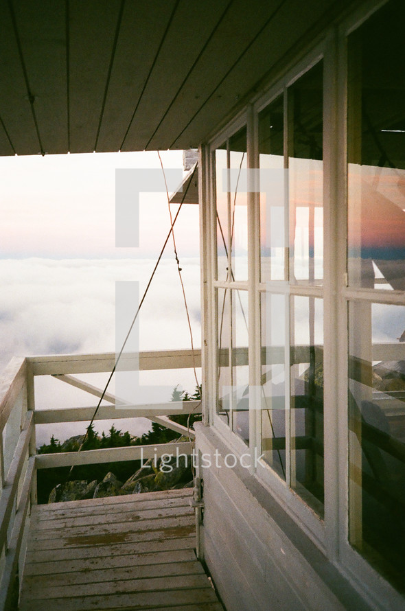 deck overlooking fog on a mountain at sunrise 
