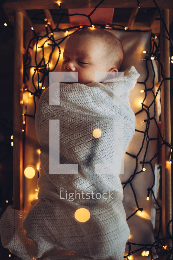 Christmas lights around baby Jesus in the manger 
