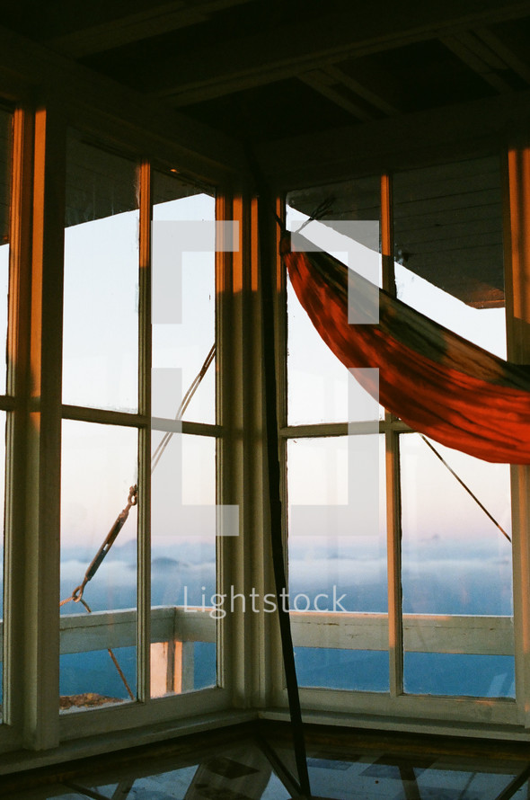 hammock on a deck overlooking mountain fog at sunrise 