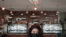 a woman in a cafe wearing a face mask 