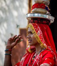 a woman in India balancing items on her head 