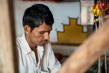 a man making a rug in India