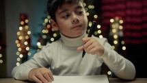 Kid writing Italian Buon Natale on his notebook 