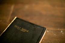 A Holy Bible resting on a wood table