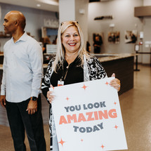 a woman holding a sign that reads you look amazing today 