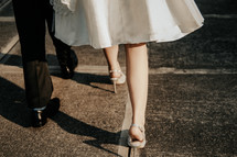 legs of a bride and groom on a crosswalk 