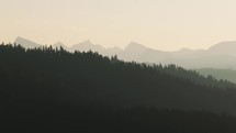 Aerial of forest, hills and mountains in sunset