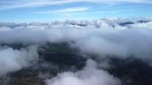Foggy fog blows over spruce forests. Aerial shots of spruce forests on mountain hills during a foggy day. Low and central clouds in the morning.Drone view, bird’s eye view, real time footage