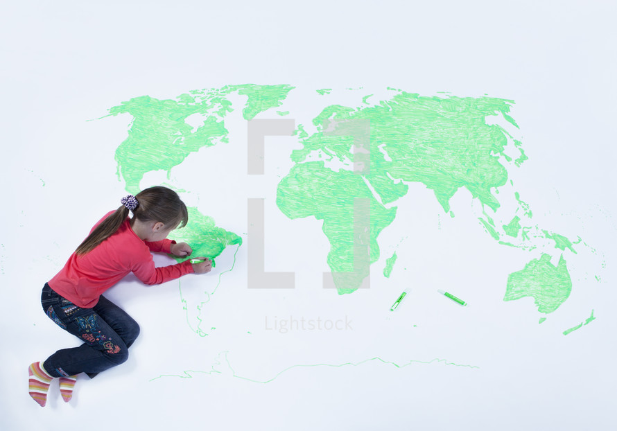 Top view of young girl drawing a map of the world	