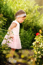 toddler girl standing outdoors in a skirt and head band 