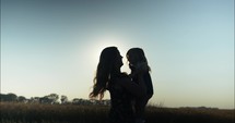 Happy mother and daughter playing in summer sunset.