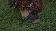 Woman Outside in Meadow Takes of Shoes and walks Barefoot - Close Up on Feet