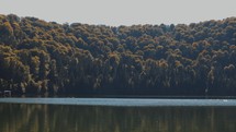 Autumn Landscape Of Lake Saint Ann In Romania With Forest Trees Reflecting On Water - panning