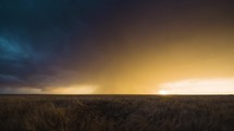 A Field of Wheat Sways in the Strong Winds Below a Colorful Stormy Sunset.