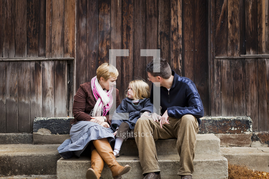 family sitting together on steps outdoors
