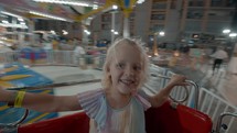 Happy girl in merry-go-round in the evening