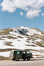 van parked by a snow covered hill 