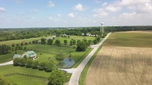 Drone shot of a road in a rural area with a water tower in the background.