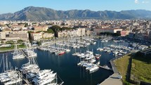 Aerial shot drone flies up and over boat marina in Palermo, Sicily, Italy