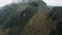 Mountain Peak Shrouded By Fog And Clouds In The Early Morning In Cayambe Coca Ecological Reserve In Napo, Ecuador. - aerial tilt up