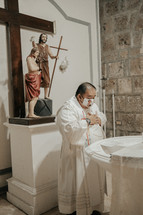 a priest at a baptismal font 