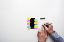 Top view of a man putting sticky notes on to a smart phone- for editorial use only 