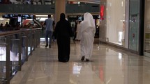Middle eastern man and woman, married couple in Dubai mall shopping.