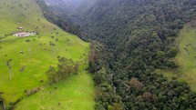 Aerial shot drone flies forward over stream in middle of foggy Cocora Valley