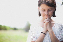 Girl praying outside.