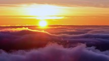 Experience the captivating beauty of the sunrise above the rolling clouds. 