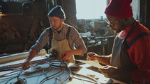 Blacksmith Measuring Wrought Iron as Colleague Writing Results in Workshop