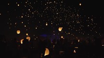 Slow tilt up of hundreds of Chinese lanterns floating in the night sky.