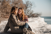 couple sitting on a shore in winter 