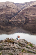 a couple standing by a lake 