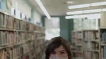 a girl wearing face masks at a library 