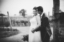 bride and groom standing in a  vineyard 