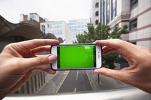 Personal perspective of a man using a smartphone with a green screen - for editorial use only 	