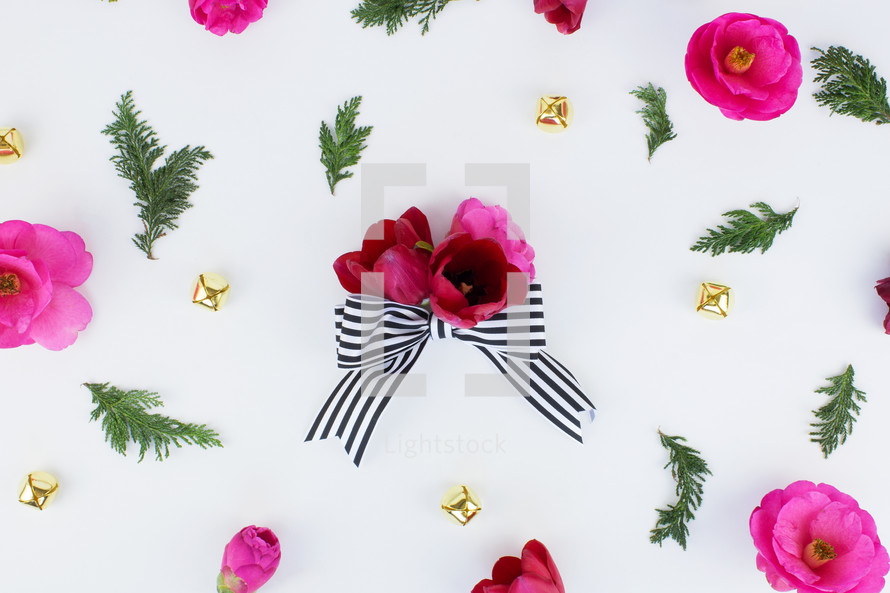 flowers, pine, and bows scattered on white background 