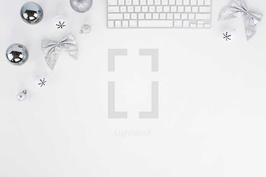 computer keyboard and silver Christmas decorations on a desk 