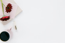 iPhone, red gerber daisies, nail polish, coffee mug, stationary, white background 
