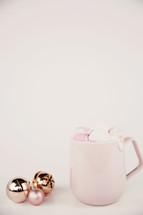 pink mug and Christmas ornaments 