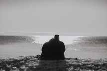a couple sitting on a shore 