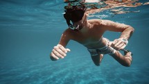 Boy swims style in open ocean water