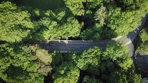 Aerial View of Cars and Cyclists Going Over a Bridge in the Enniskerry Woodland, Ireland