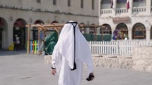 Qatari man walking in front Souq Waqif in Doha Qatar
