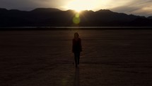 Woman Walking Towards Camera In Desert